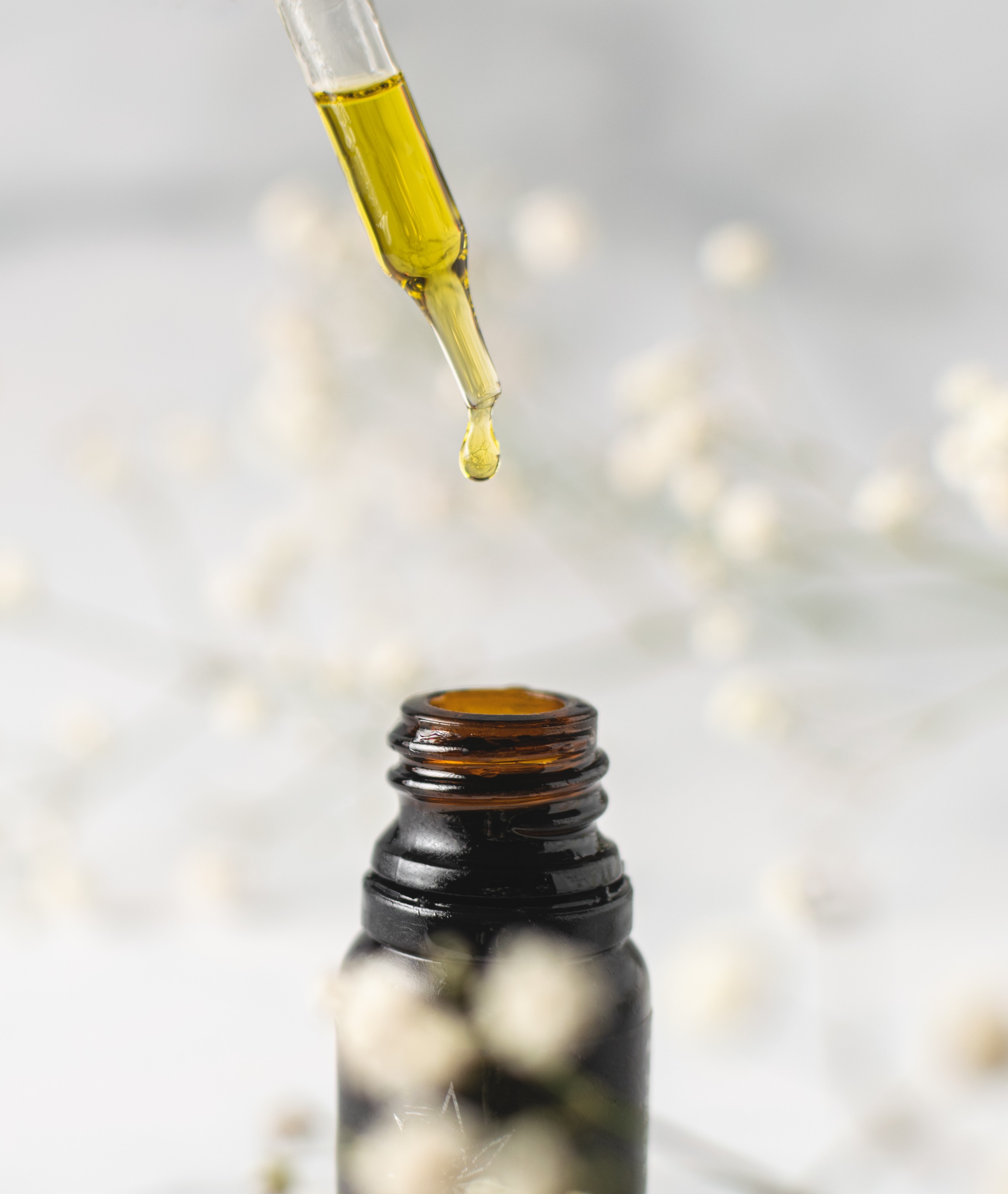Pipetă cu ulei picură ulei într-o sticluță